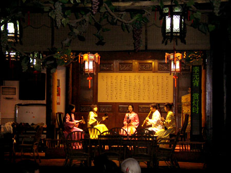 夜幕降临，人民在茶楼一边品茶一边观看南音